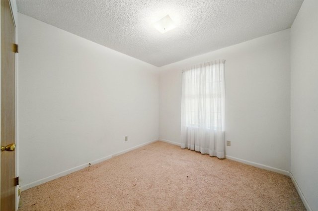 carpeted empty room with baseboards and a textured ceiling