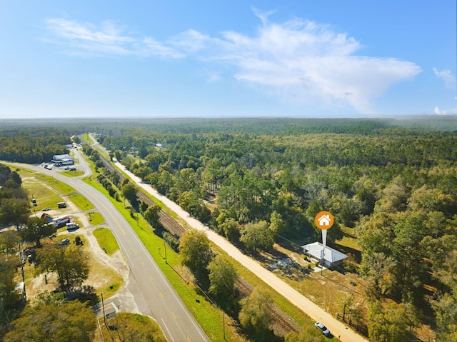 bird's eye view with a wooded view