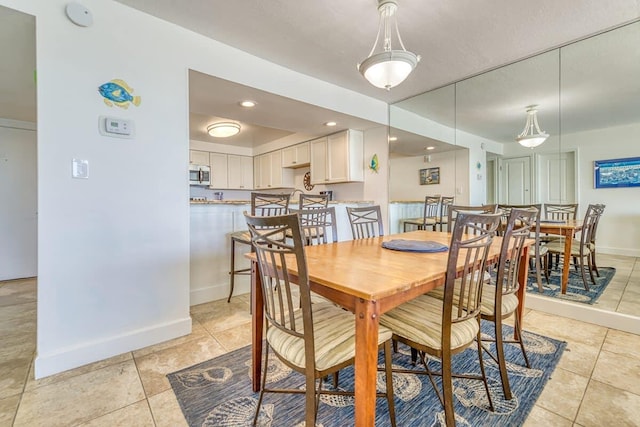 dining room with light tile patterned floors, baseboards, and recessed lighting