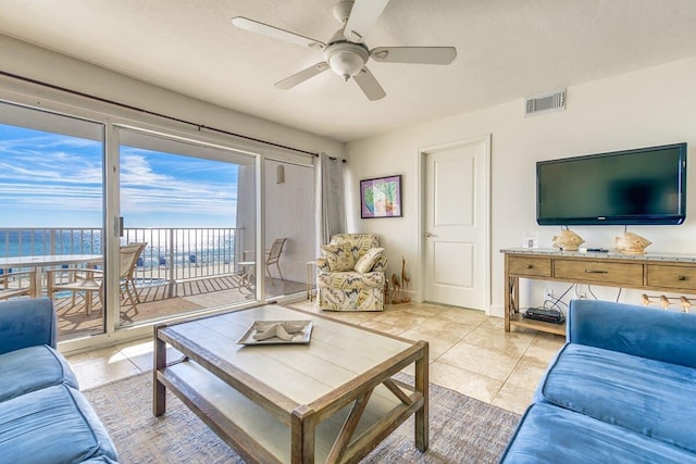 living area featuring light tile patterned floors, visible vents, and a ceiling fan