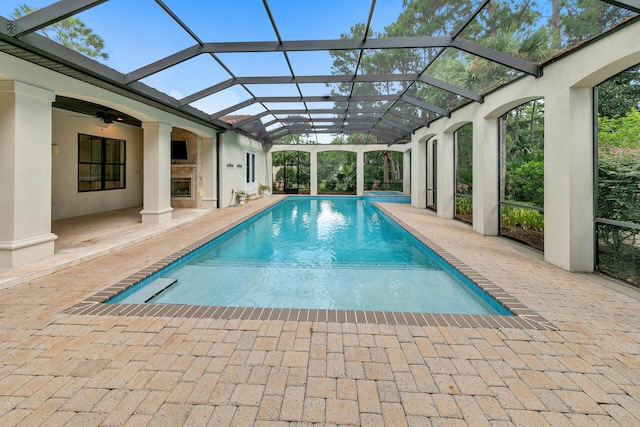 view of pool featuring a lanai, a patio, ceiling fan, and a pool with connected hot tub