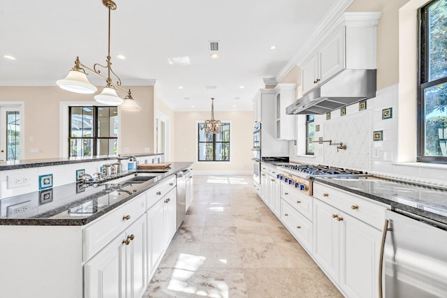 kitchen with a sink, dark stone countertops, tasteful backsplash, stainless steel appliances, and white cabinets