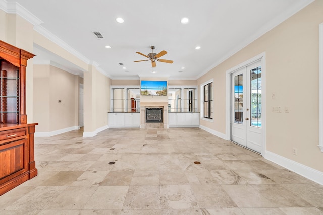 unfurnished living room with visible vents, baseboards, a fireplace, and crown molding