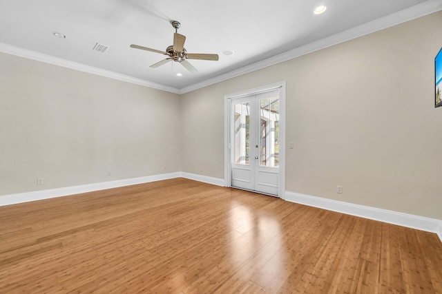 spare room featuring visible vents, light wood-type flooring, baseboards, and ornamental molding