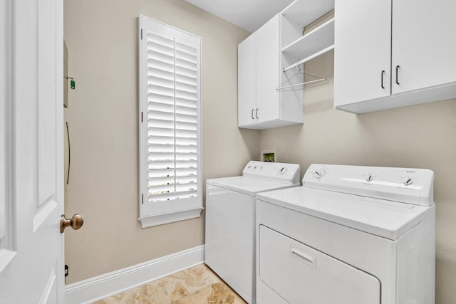 clothes washing area with washer and dryer, baseboards, and cabinet space