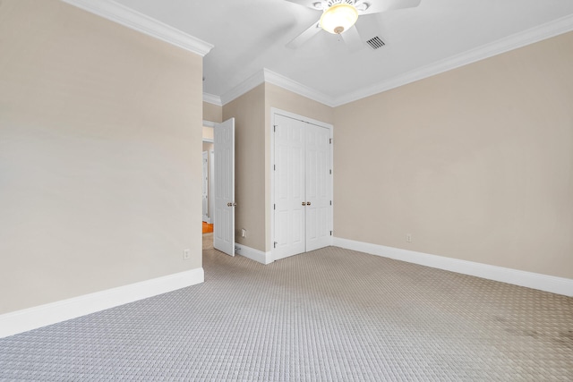 unfurnished bedroom featuring visible vents, baseboards, a closet, crown molding, and light colored carpet