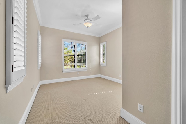 carpeted empty room with a ceiling fan, baseboards, and ornamental molding