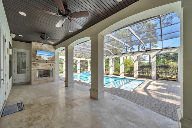 outdoor pool with a lanai, ceiling fan, a fireplace, and a patio