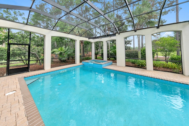 view of pool with glass enclosure, a patio area, and a pool with connected hot tub