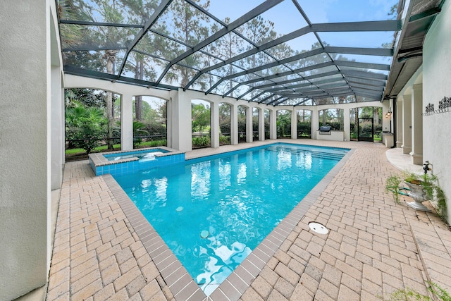 view of swimming pool featuring a patio, a lanai, and a pool with connected hot tub