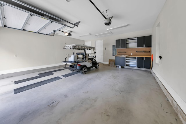 garage featuring electric panel, baseboards, and a garage door opener