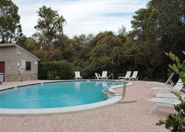 community pool with a patio area and fence