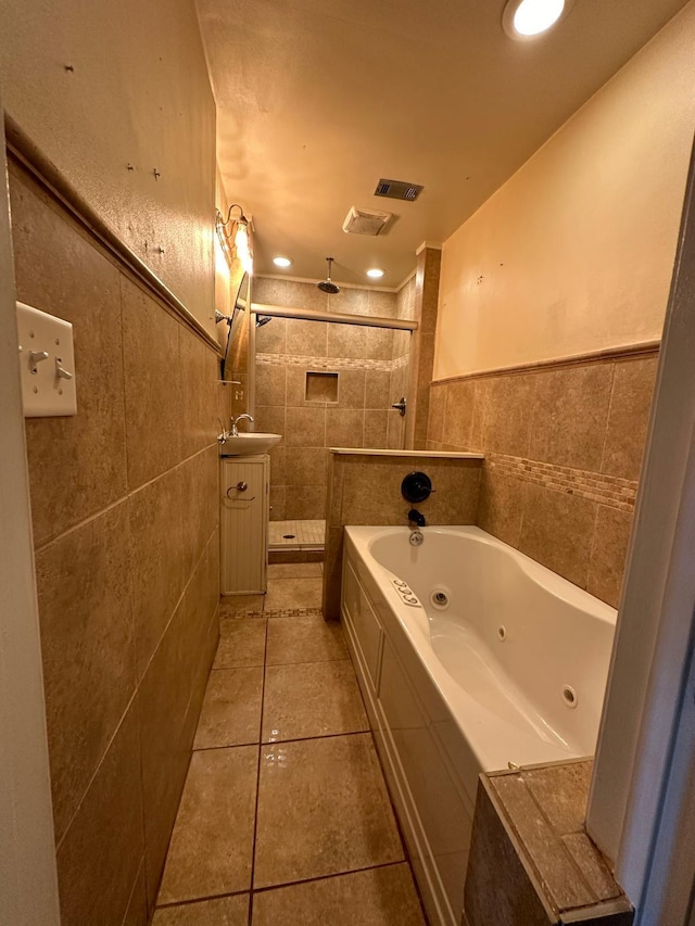 full bath featuring visible vents, a tile shower, tile walls, a tub with jets, and tile patterned flooring