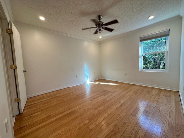 spare room with baseboards, light wood-style flooring, ceiling fan, a textured ceiling, and crown molding