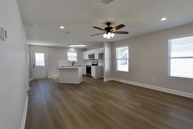 kitchen with visible vents, dark wood-type flooring, white cabinets, stainless steel appliances, and a sink