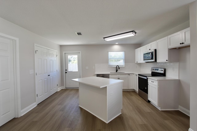 kitchen with wood finished floors, visible vents, appliances with stainless steel finishes, and a sink