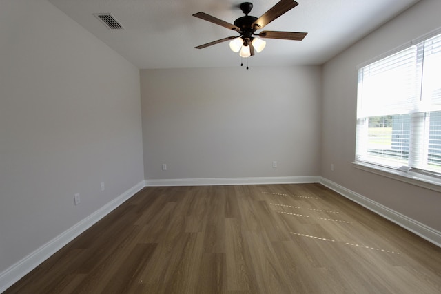 unfurnished room with visible vents, a ceiling fan, baseboards, and wood finished floors