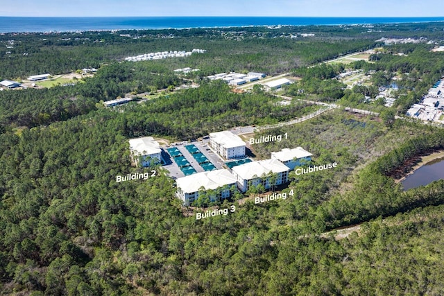 drone / aerial view with a water view and a wooded view