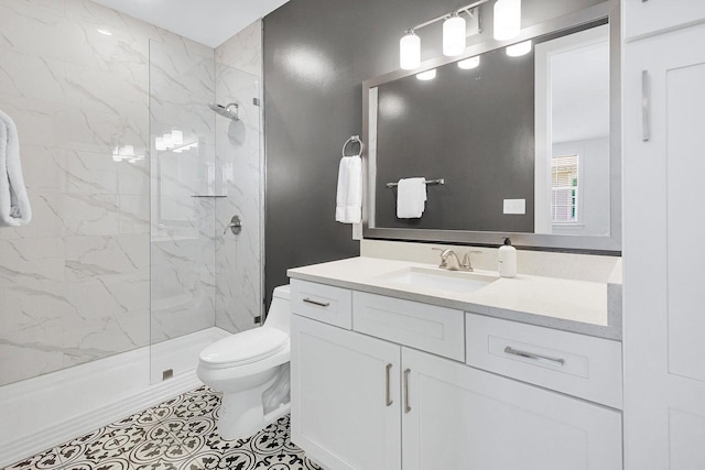 bathroom with a marble finish shower, toilet, and vanity