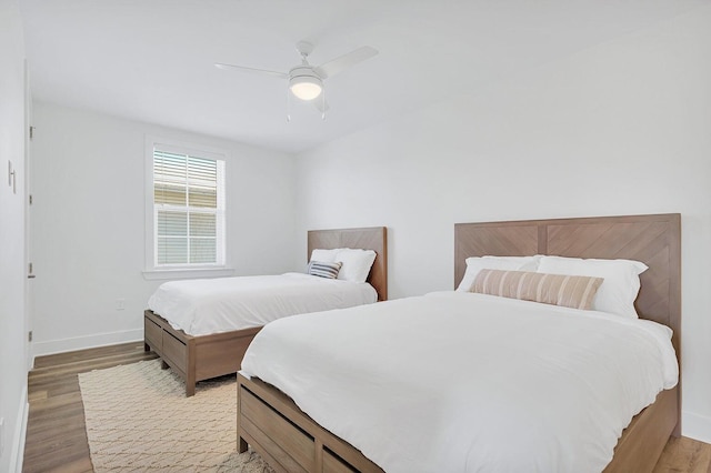 bedroom featuring a ceiling fan, light wood-type flooring, and baseboards