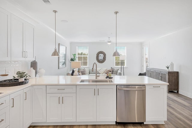 kitchen featuring a sink, stainless steel dishwasher, open floor plan, a peninsula, and light countertops