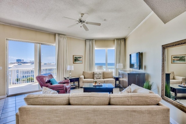 living area with ornamental molding, a ceiling fan, and a textured ceiling