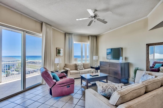 living room featuring a water view, a ceiling fan, a textured ceiling, crown molding, and light tile patterned floors