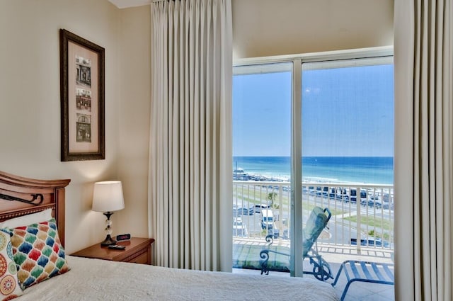 bedroom featuring a view of the beach, access to outside, and a water view