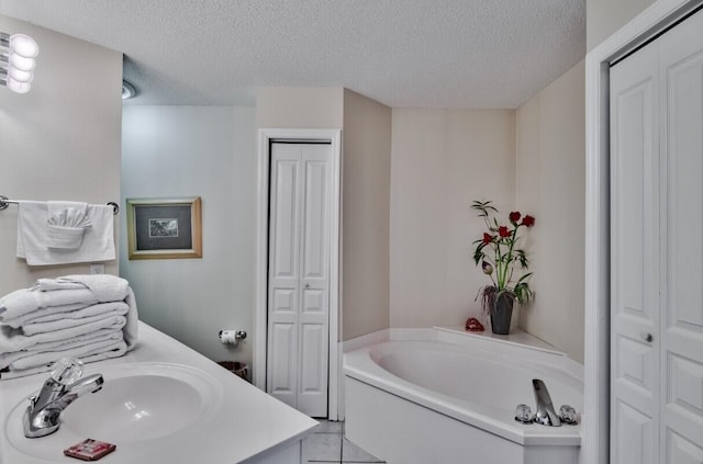 full bathroom featuring a closet, a textured ceiling, a bath, and vanity