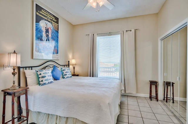 bedroom featuring tile patterned floors, a ceiling fan, baseboards, and a closet