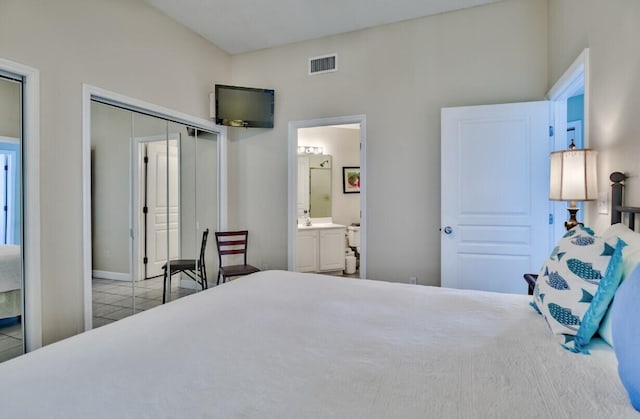 bedroom featuring tile patterned flooring, visible vents, connected bathroom, and a closet