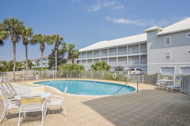 community pool featuring a patio and fence