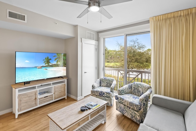 living area with visible vents, baseboards, and wood finished floors