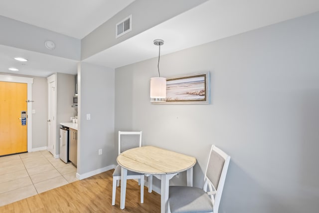 dining space with light tile patterned floors, visible vents, and baseboards