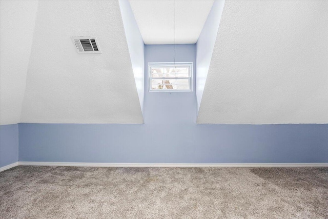 empty room with carpet, visible vents, and baseboards