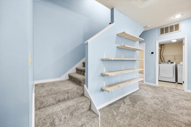 stairs featuring carpet flooring, baseboards, visible vents, and washing machine and clothes dryer