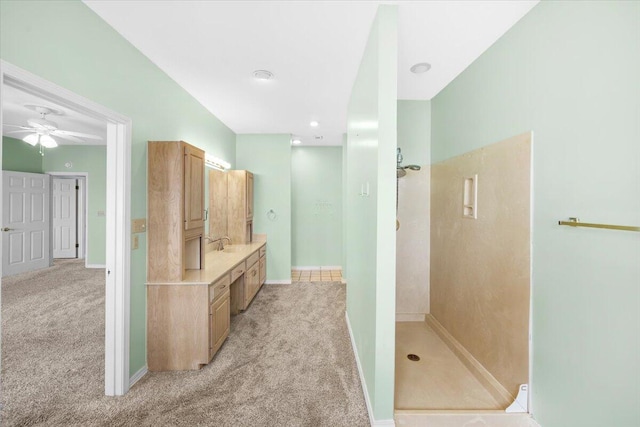 full bath with ceiling fan, vanity, baseboards, and walk in shower