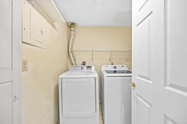 laundry area with electric panel, laundry area, and washing machine and dryer