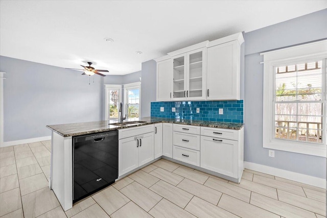 kitchen with a sink, backsplash, black dishwasher, dark stone counters, and a peninsula