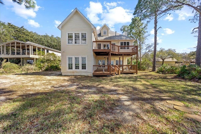 back of house with a wooden deck and a yard