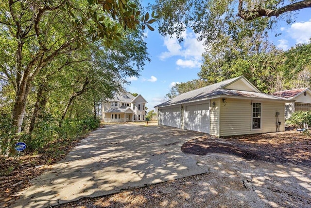 view of side of home featuring a garage and driveway