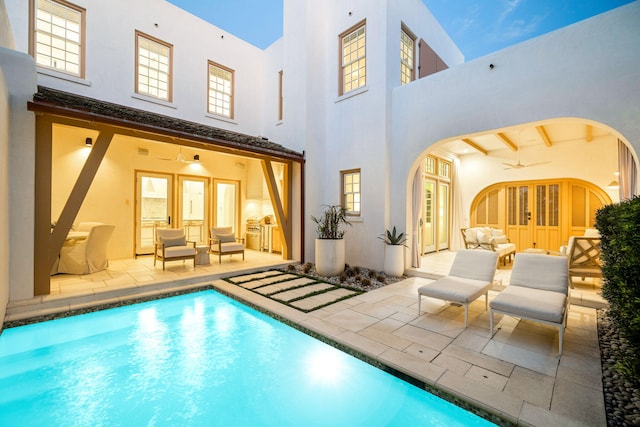 rear view of property with stucco siding, french doors, a ceiling fan, and a patio