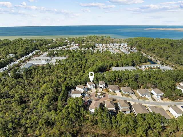 drone / aerial view with a view of trees, a water view, and a residential view