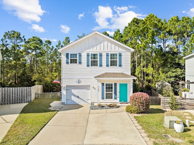 traditional home with fence, driveway, a front lawn, a garage, and board and batten siding