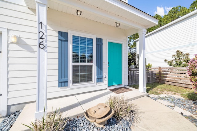 view of exterior entry featuring fence