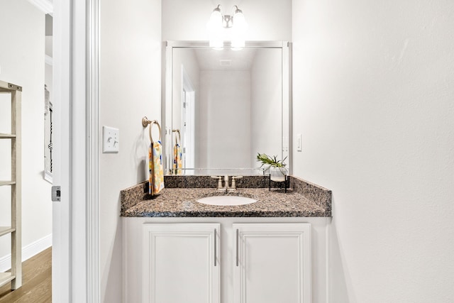 bathroom featuring baseboards, wood finished floors, and vanity