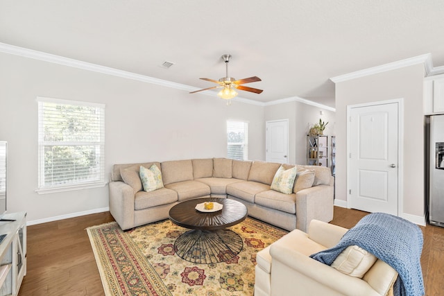 living area featuring a ceiling fan, baseboards, wood finished floors, visible vents, and ornamental molding