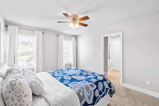 carpeted bedroom with baseboards and ceiling fan