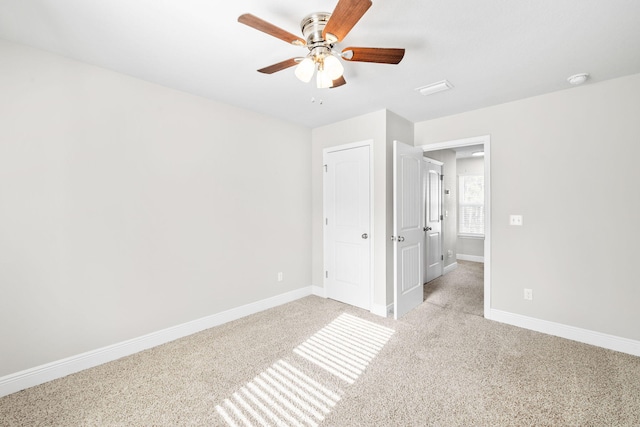 unfurnished bedroom with light colored carpet, baseboards, and ceiling fan