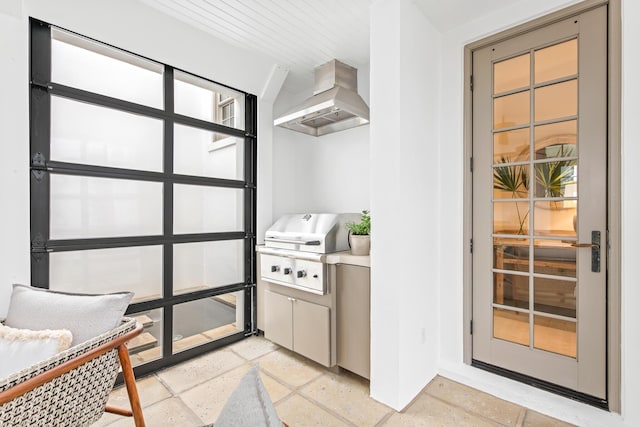 interior space with wall chimney exhaust hood and light countertops